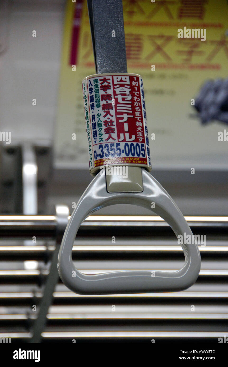 Passenger strap with advertising message on Tokyo subway train Stock Photo