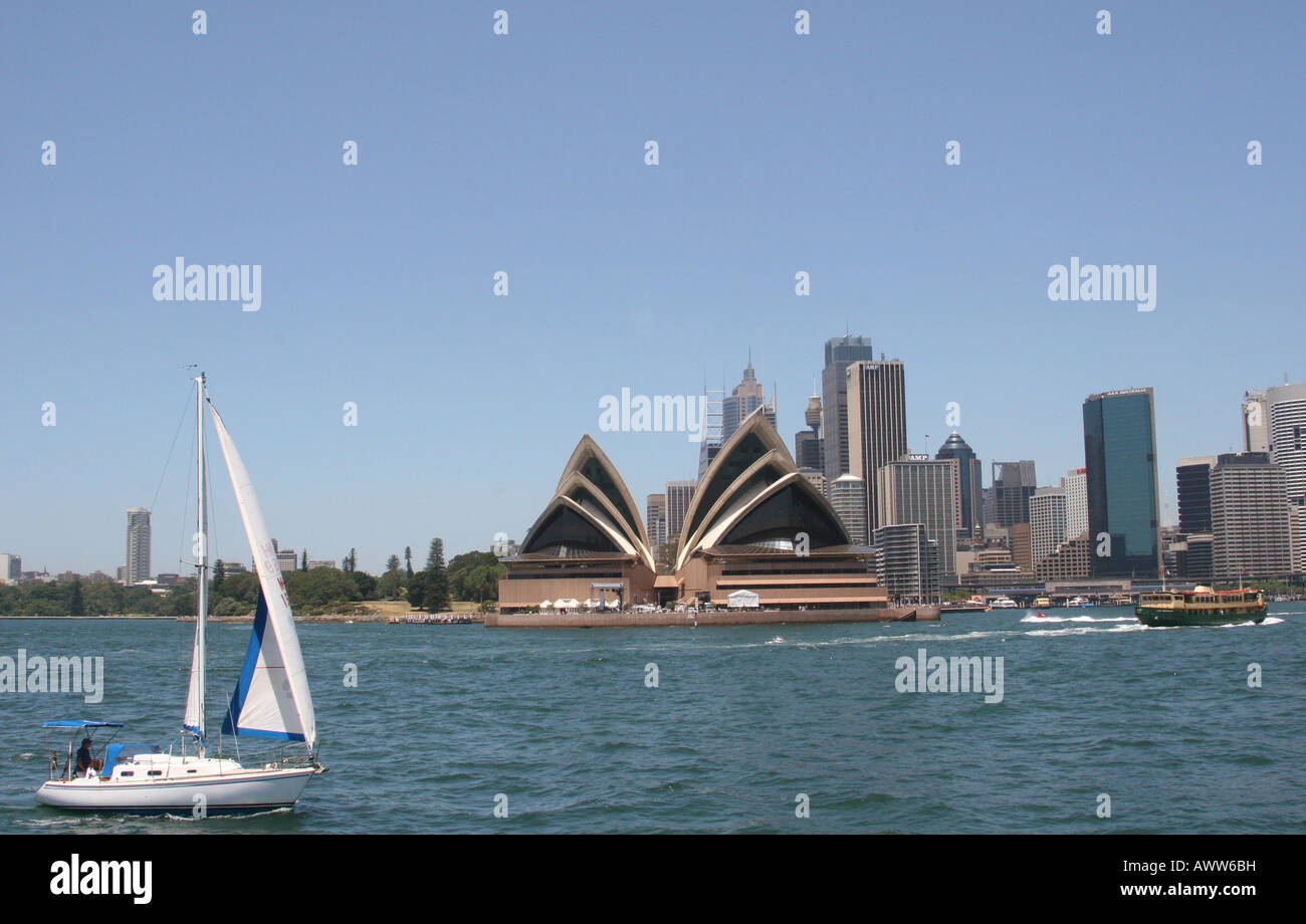Sailing boat passing the Sydney Opera House in Sydney Harbour Stock Photo