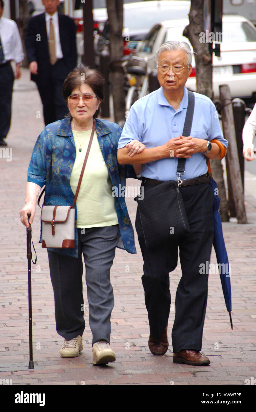 Old Japanese couple walking in Tokyo Stock Photo