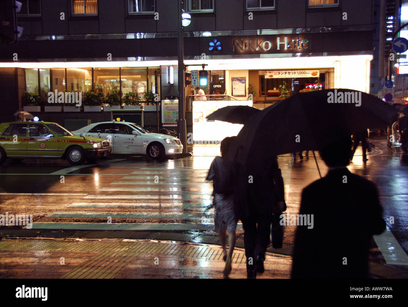 People with umbrellas crossing rainy night time Tokyo street Stock ...