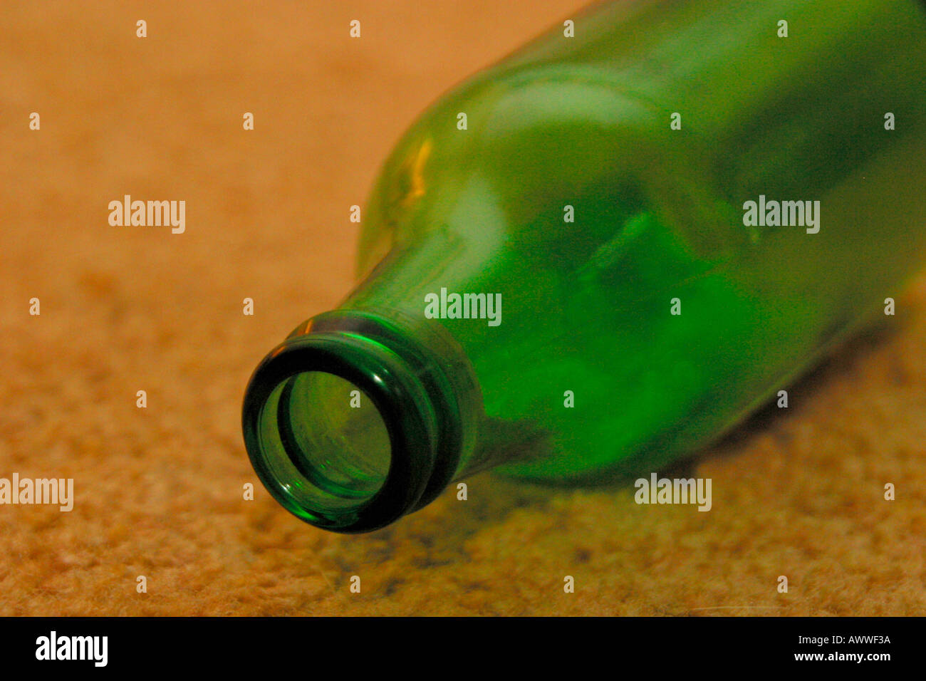 Empty beer bottle discarded on carpeted floor Stock Photo