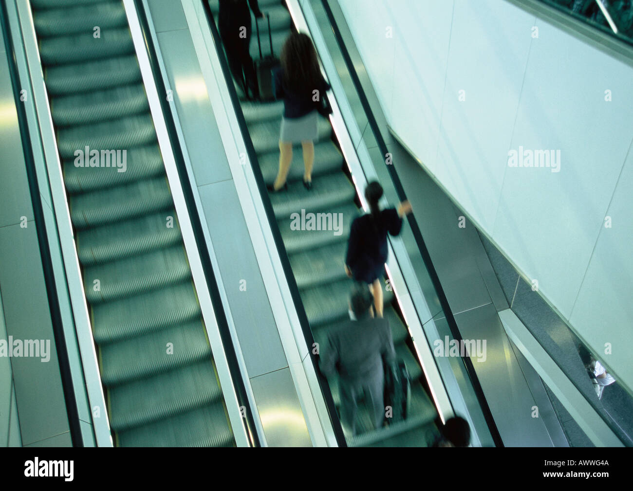 Business people on escalator going up, blurred, high angle view Stock Photo