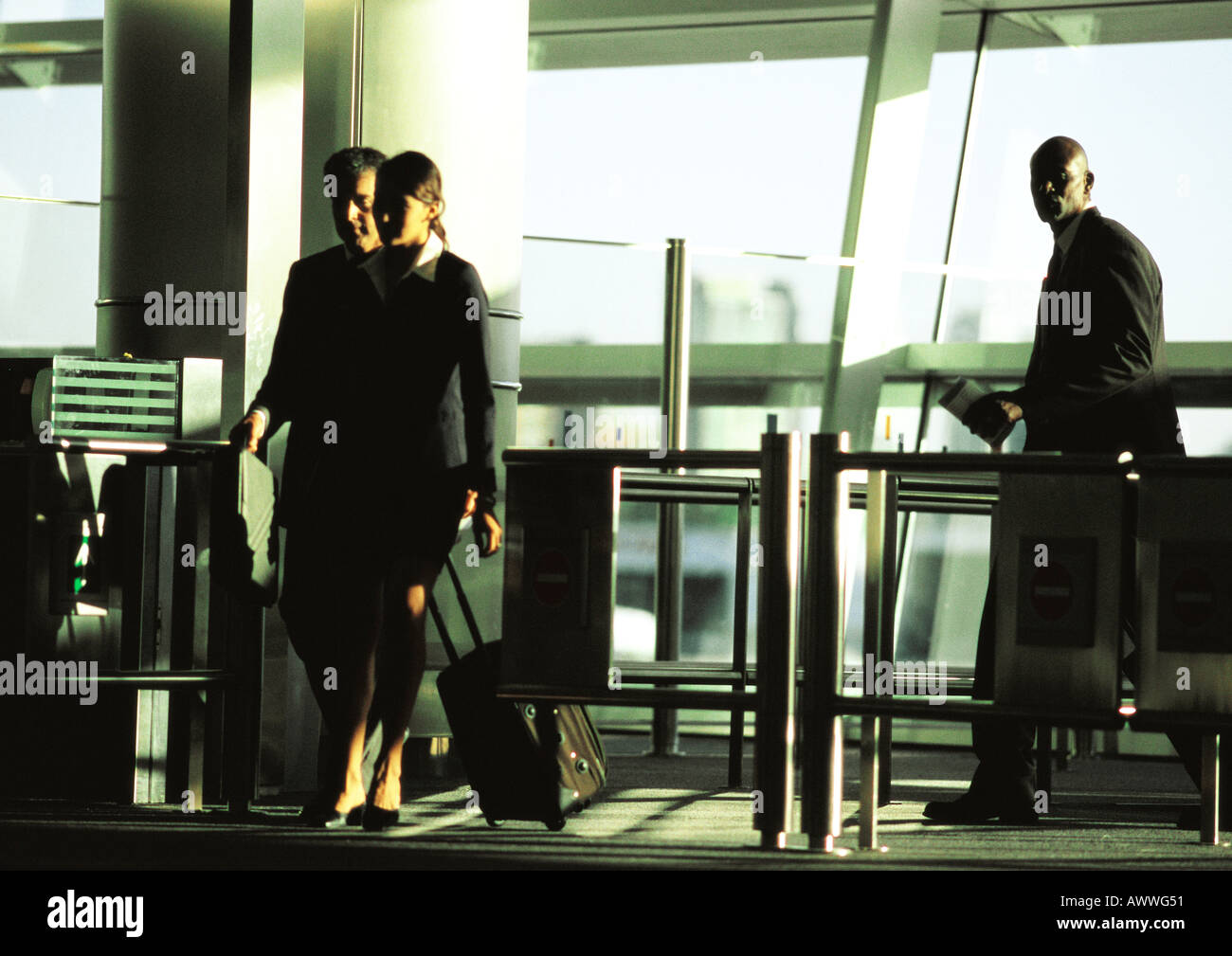 Businessman and businesswoman walking through security gate with