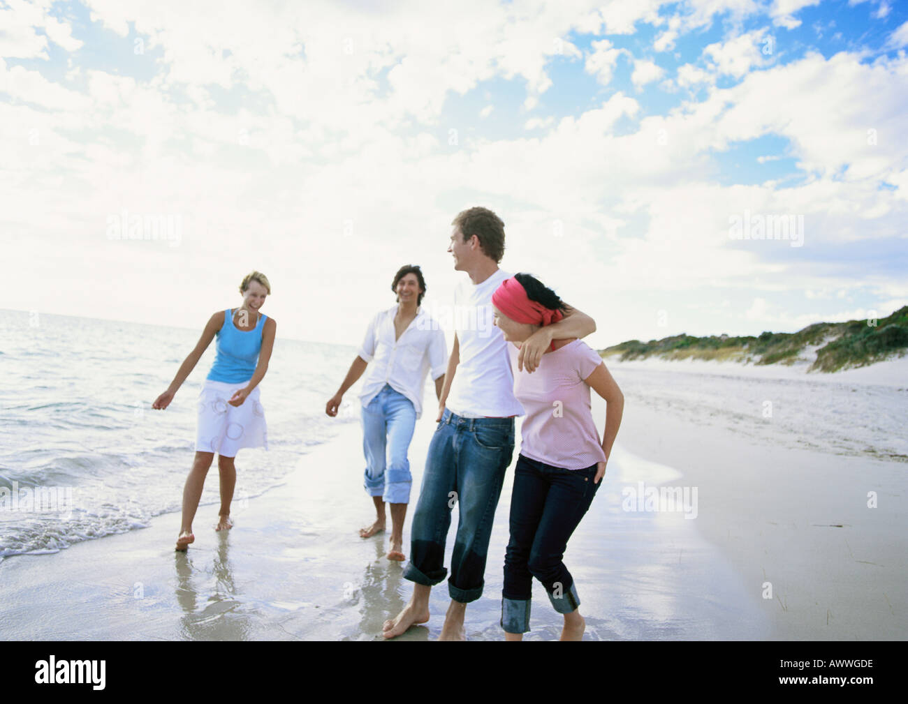 Two couples walking on beach Stock Photo