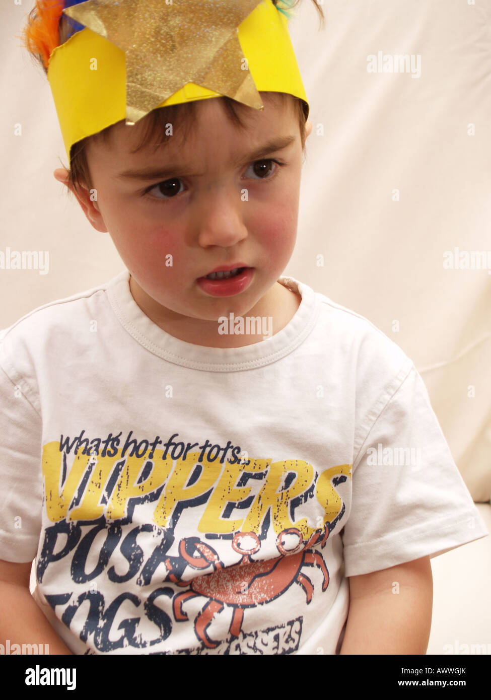 happy looking toddler home party hat curious scowl Stock Photo