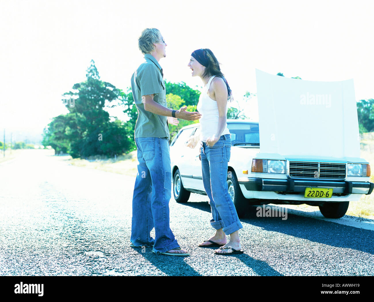 Man and woman standing in front of car with open hood Stock Photo