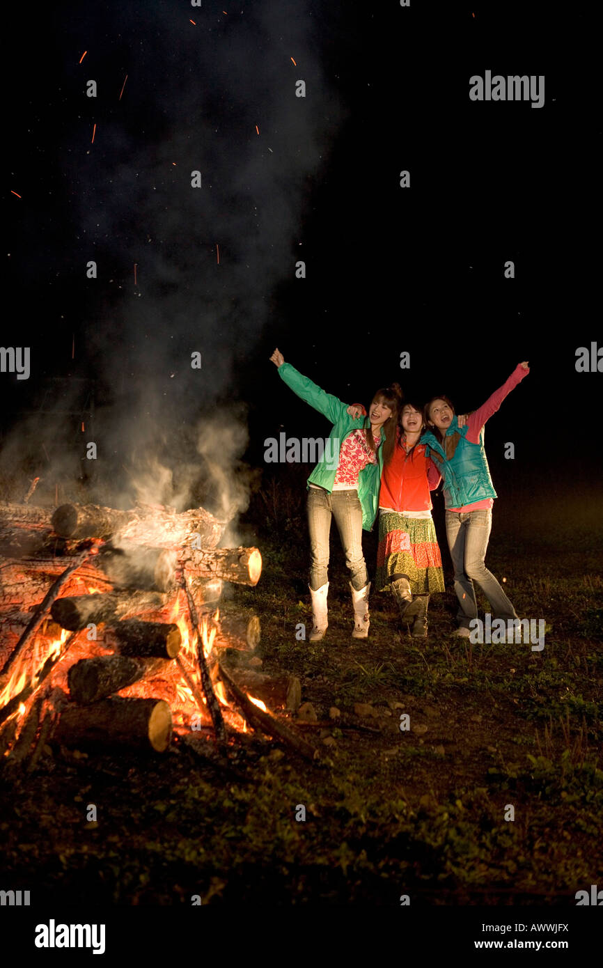Friends by campfire at night Stock Photo