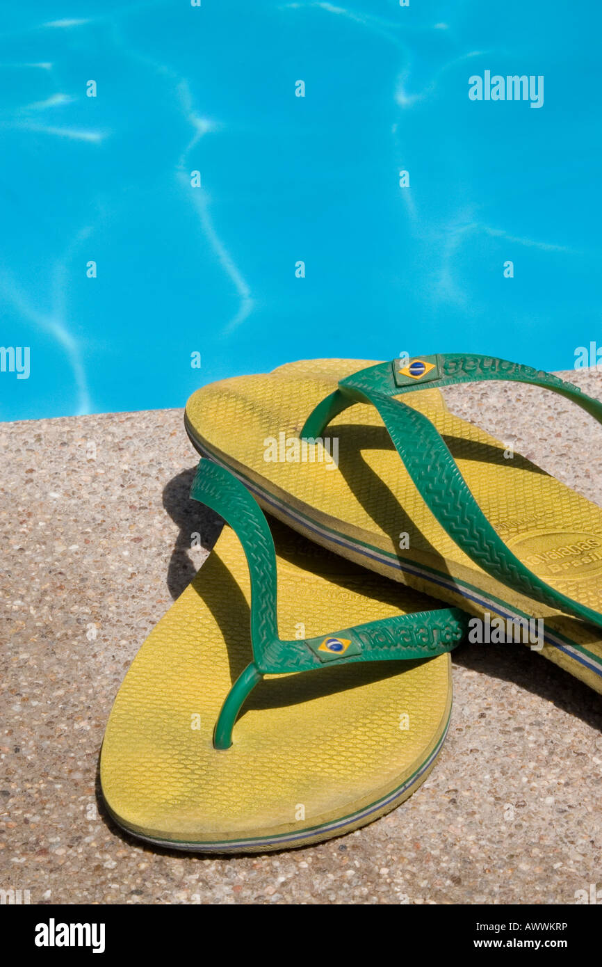 Yellow and Green Havaianas Flip Flops by Swimming Pool Stock Photo