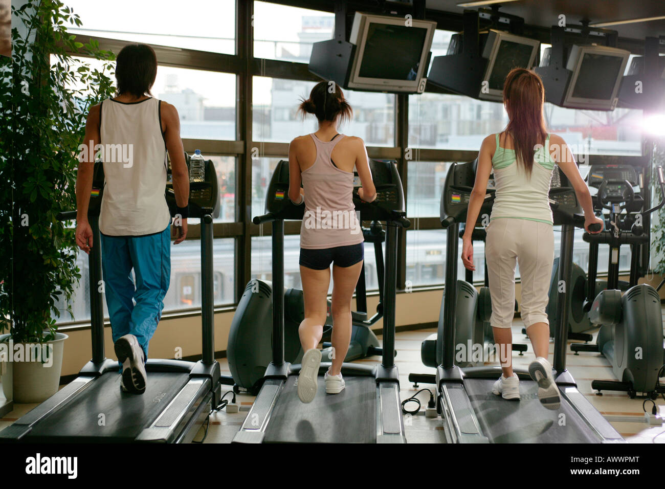 Treadmill Rear View Three people exercising on treadmills in gym, rear view Stock Photo - Alamy