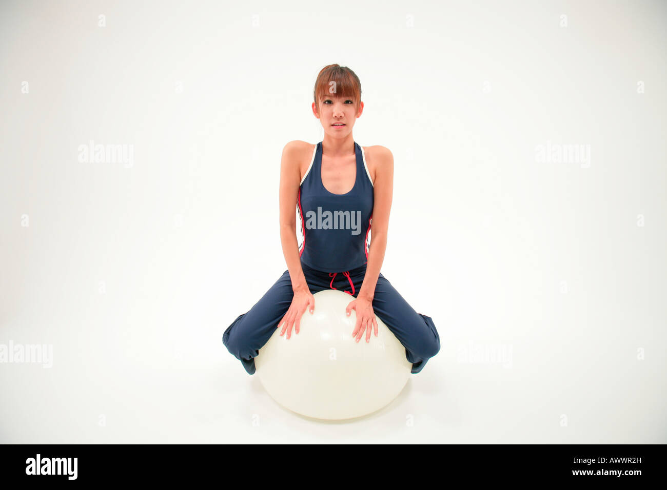Portrait of young woman sitting on exercise ball Stock Photo - Alamy