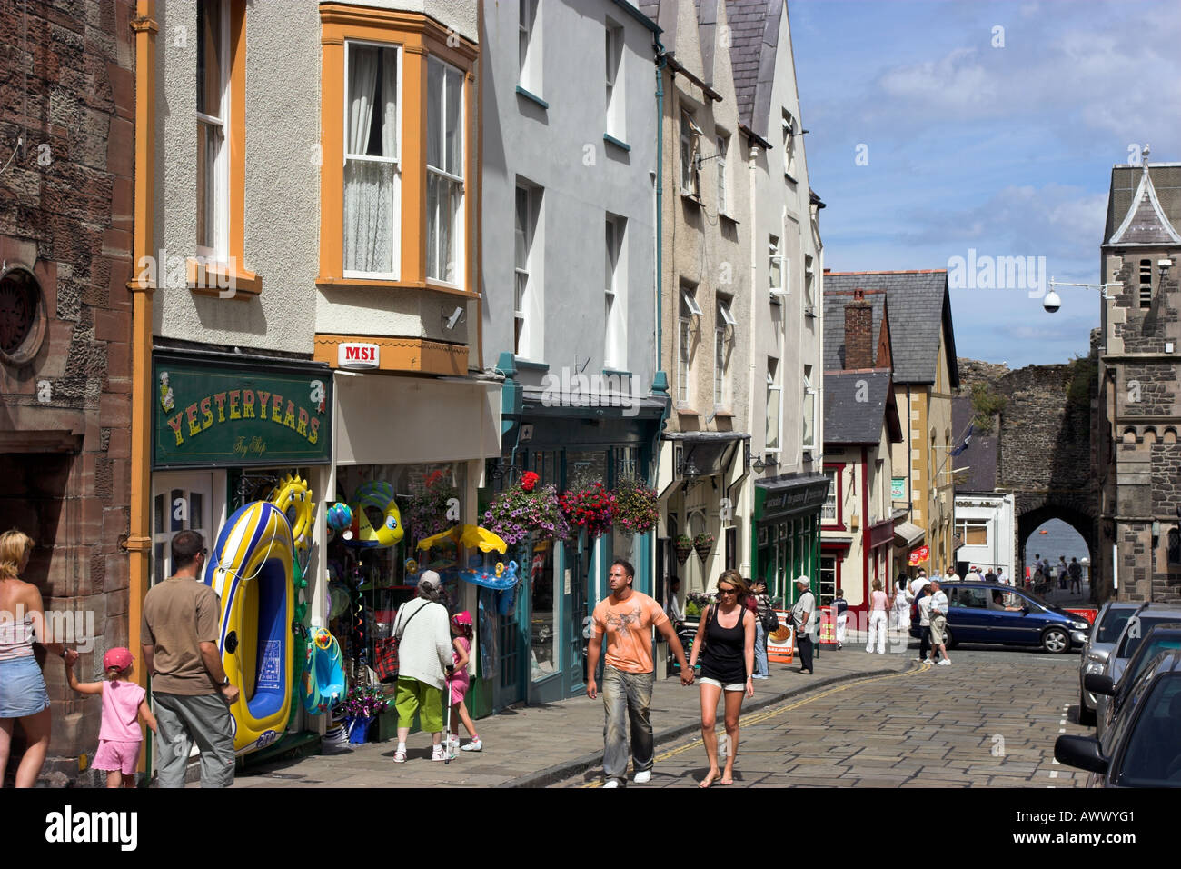 Shops on High Street leading down to old town wall and harbor in Conwy Stock Photo