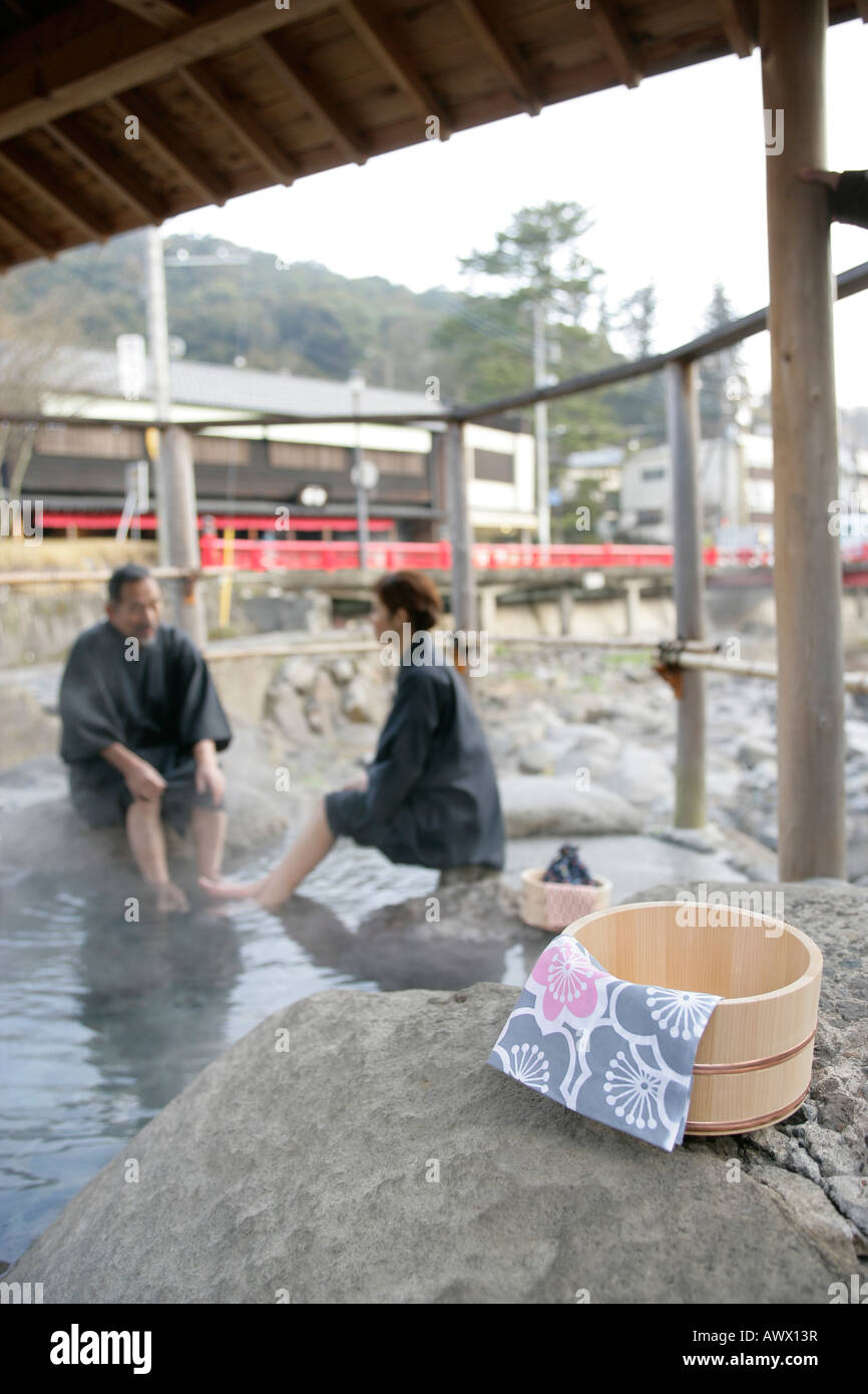 Wooden bucket in japanese spa with man and woman on background Stock Photo