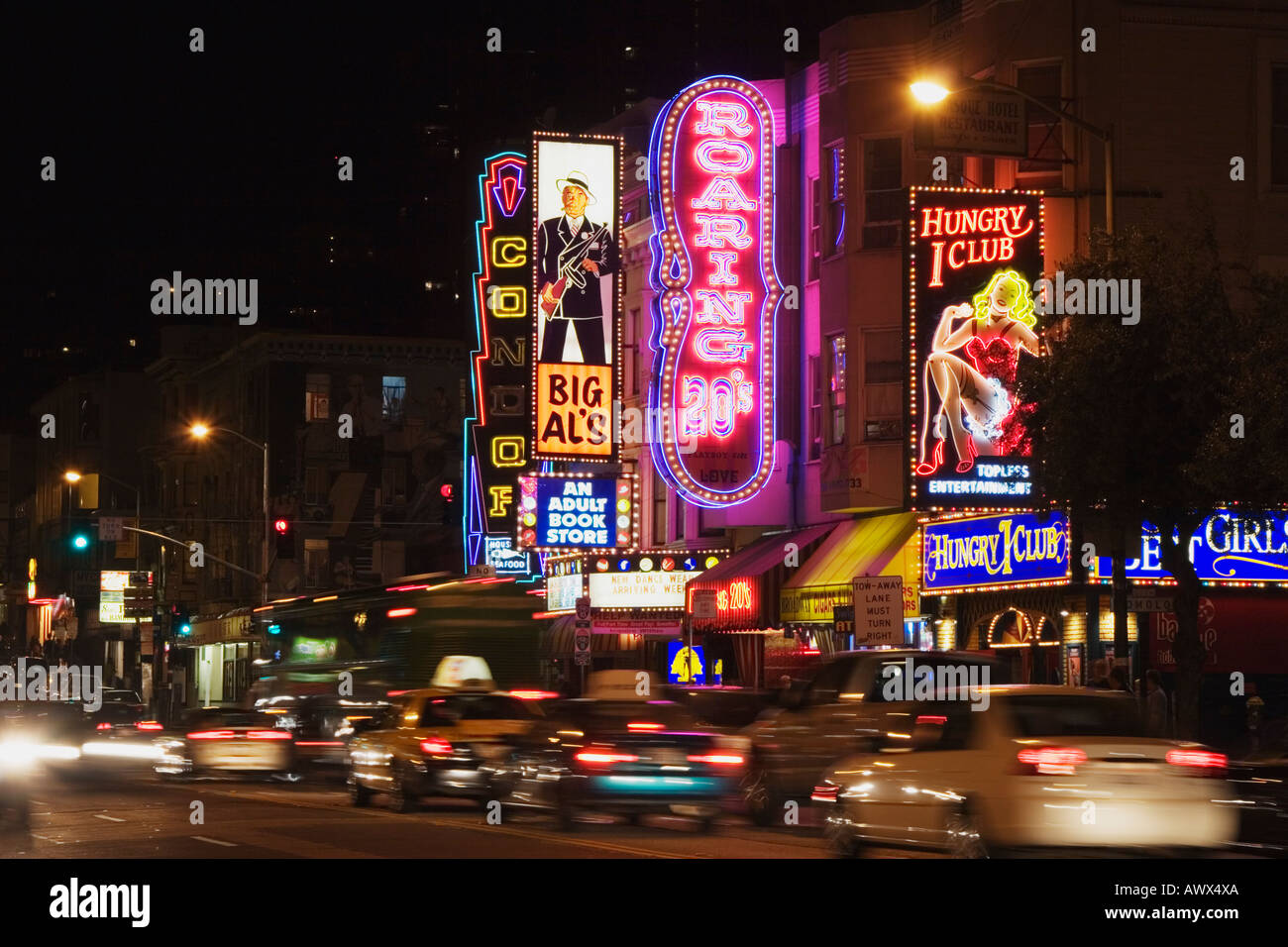 Neon signs glow at night above Broadway Street in the North Beach Stock