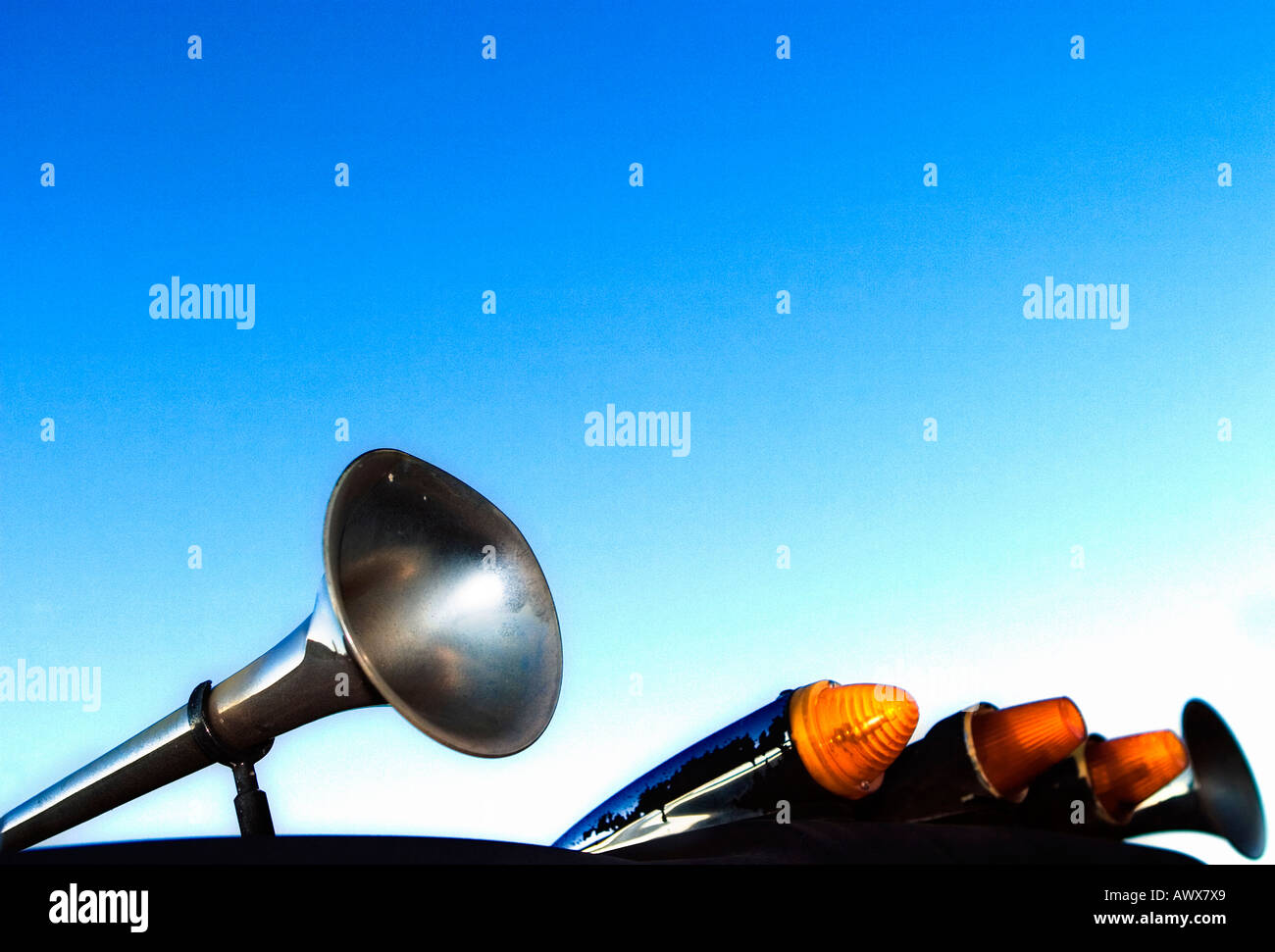minimalism style image of horns and lights from the roof of a truck set against a blue cloudless sky Stock Photo