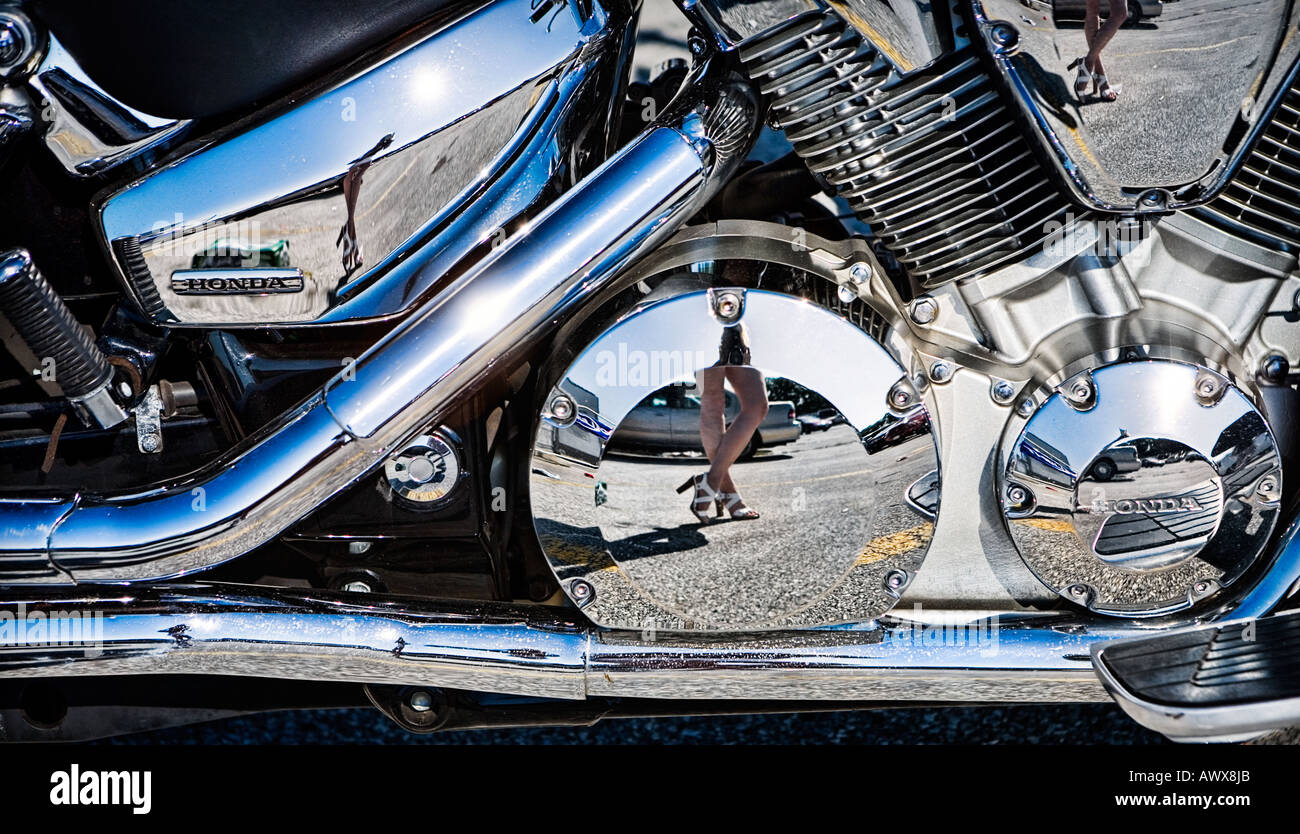 closeup of motorcycle with female legs reflecting in the chrome Stock Photo