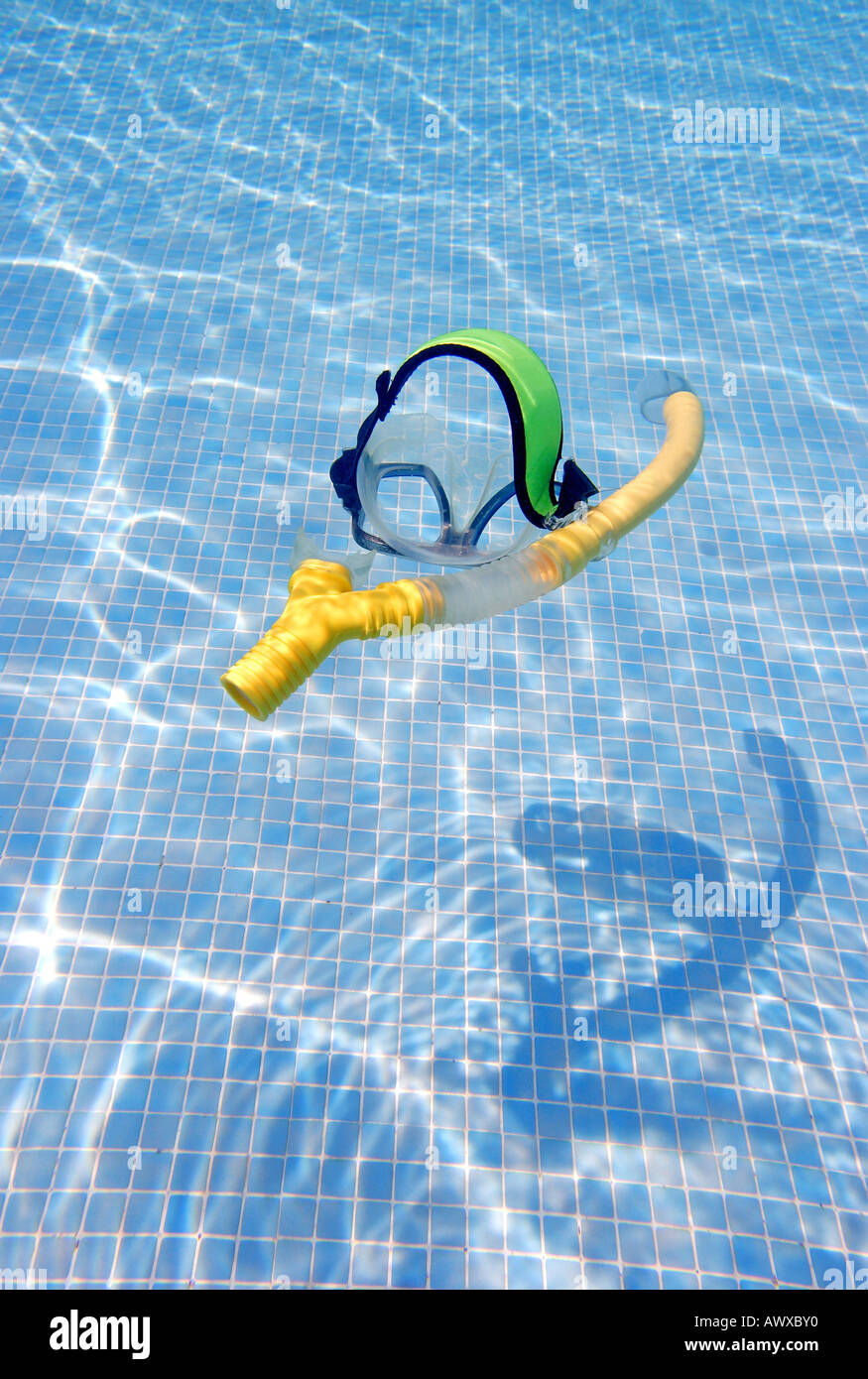 Snorkel and Goggles floating underwater in a sunny swimming pool Stock