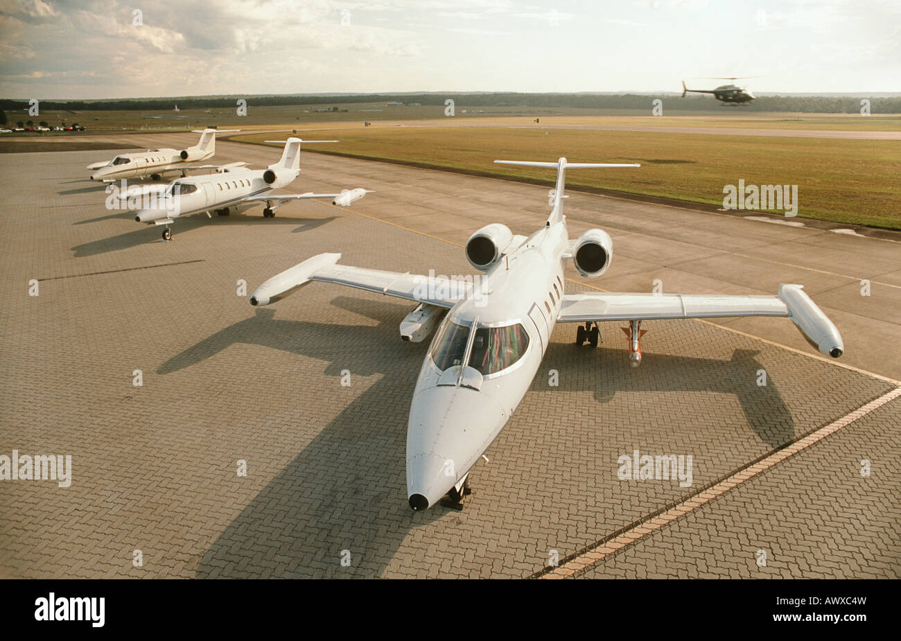 Three jet plains at airport, helicopter in background, elevated view Stock Photo