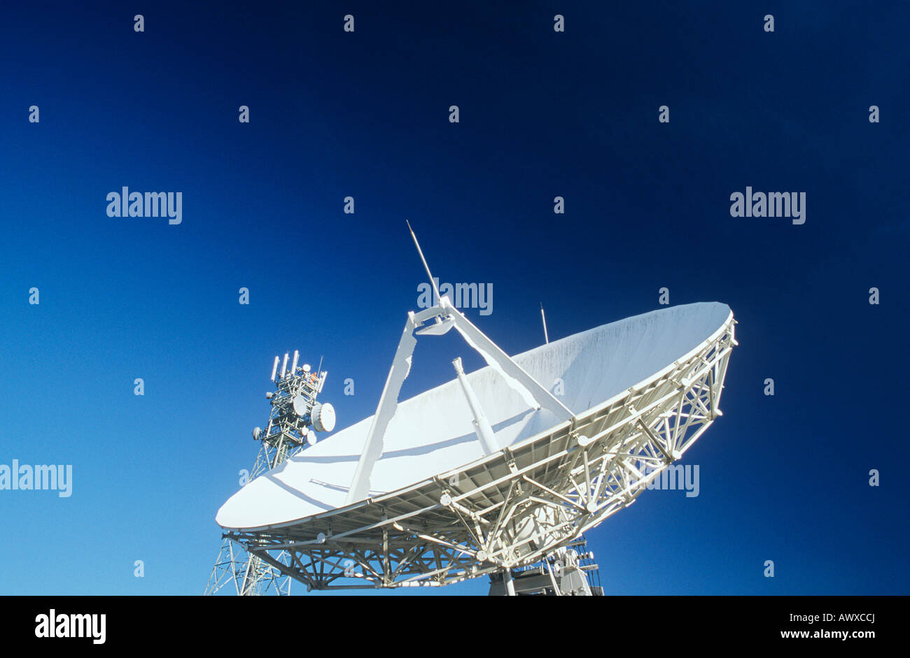 Telecommunications satellite dish and communications towers Stock Photo