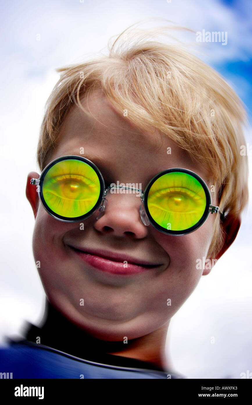 5 year old boy in joke specs pulling funny face against sky background Stock Photo