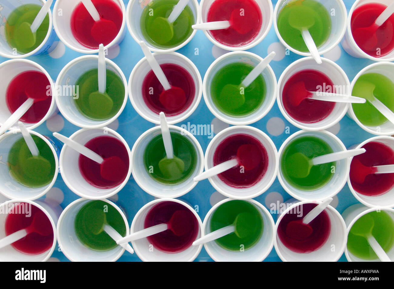 red and green jelly set in plastic cups on a tray in preparation for a children