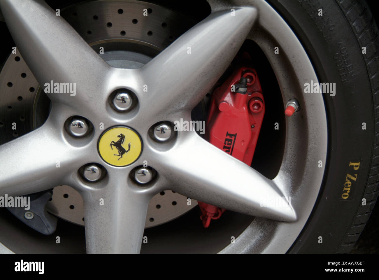 ferrari car wheel tyre rubber metal supercar car high performance brand value logo prancing horse brake disk wheel nut nuts fast Stock Photo