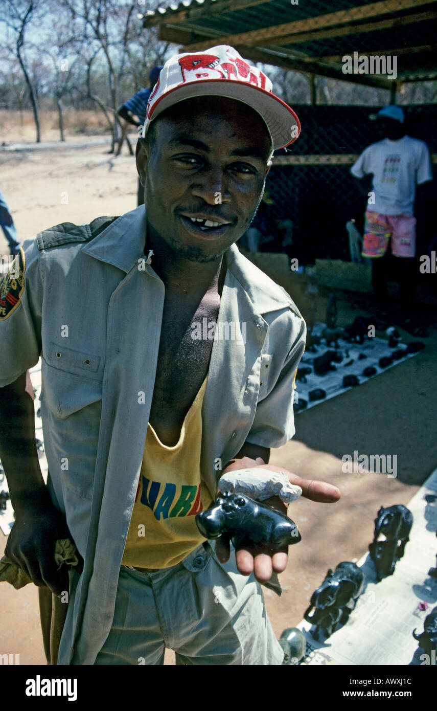 African man selling soapstone carved tourist souvenirs Victoria Falls