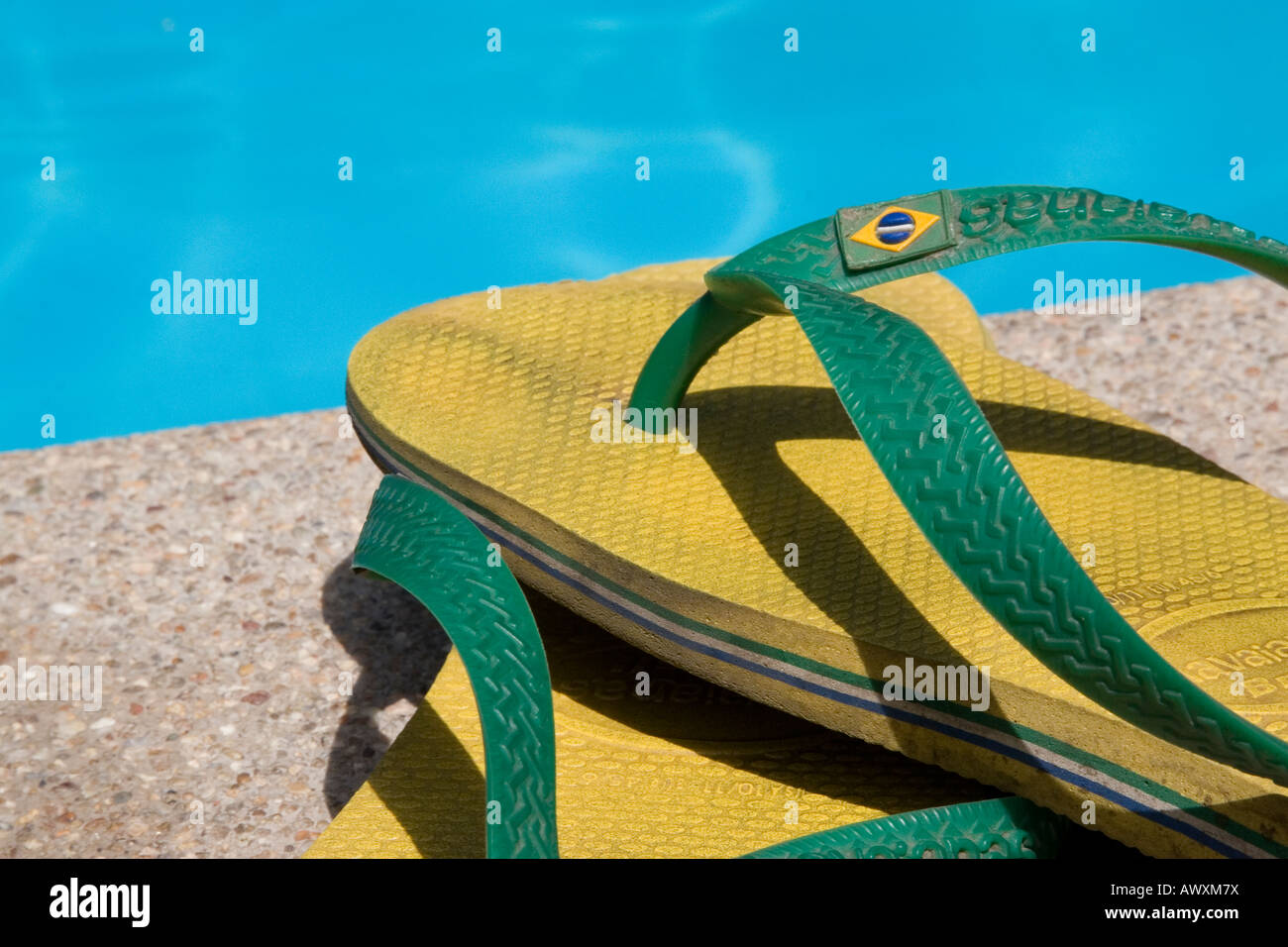 Yellow and Green Havaiana Flip Flops by Swimming Pool Stock Photo