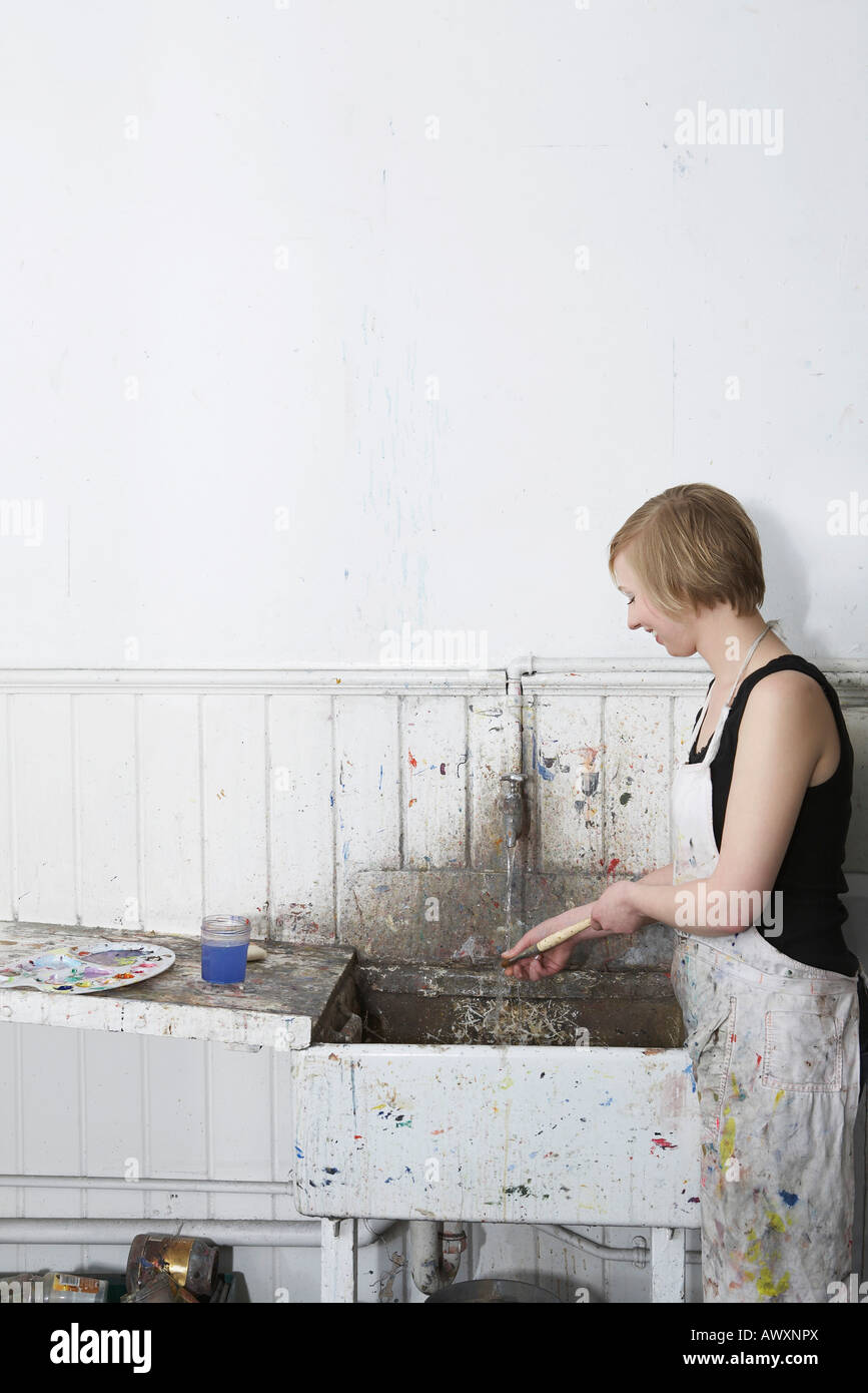 Artist cleaning paintbrush at sink in studio, side view Stock Photo Alamy