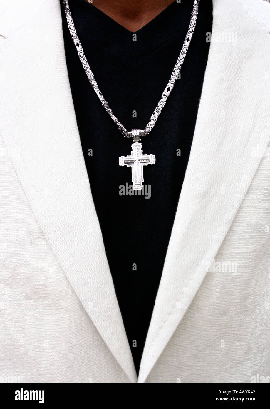 Silver cross and chain around persons neck Stock Photo