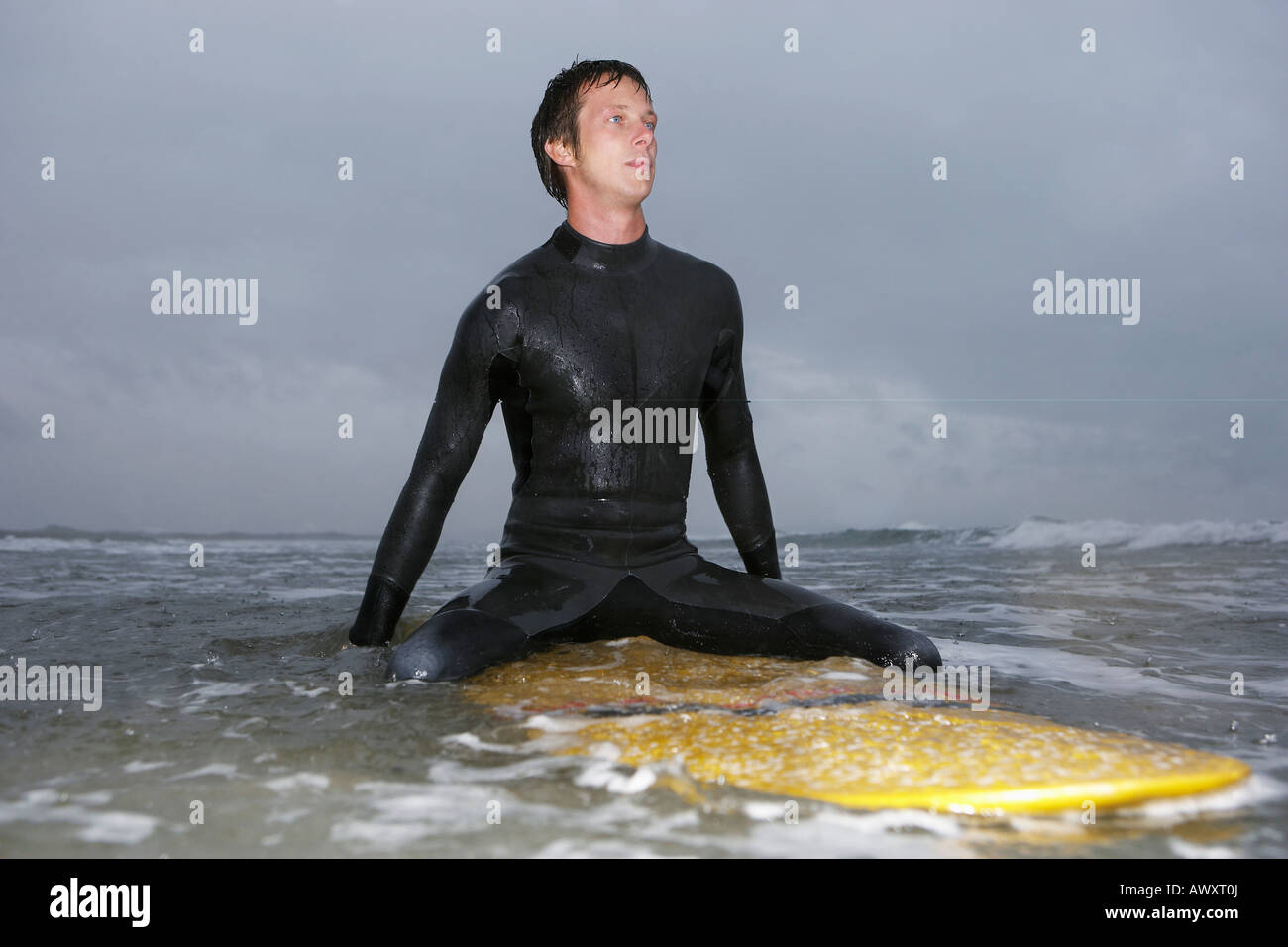 Surfer sitting on surfboard in water Stock Photo Alamy