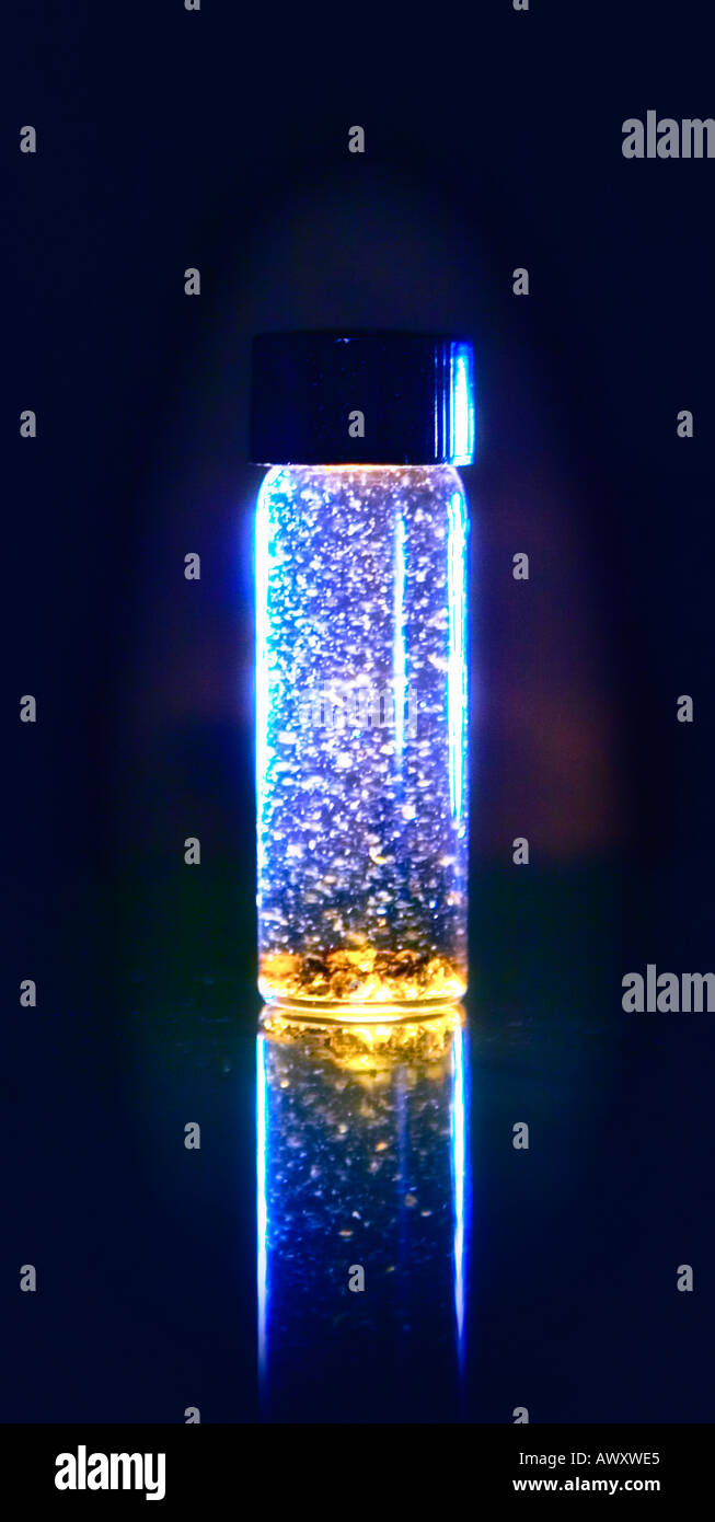 vial of gold flakes swirling around in water glowing with energy 