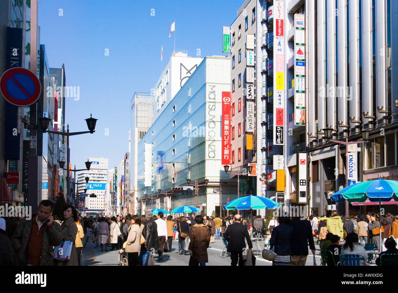People walking and shopping along Chuo Dori street on Sunday in upscale Ginza district of Tokyo Japan Stock Photo