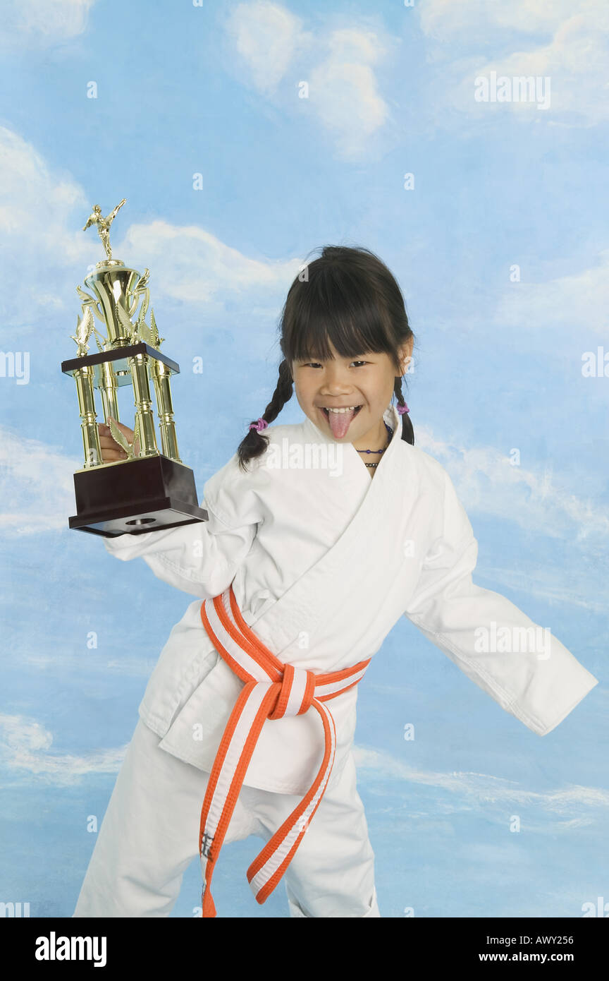 Girl in karate uniform with trophy Stock Photo - Alamy