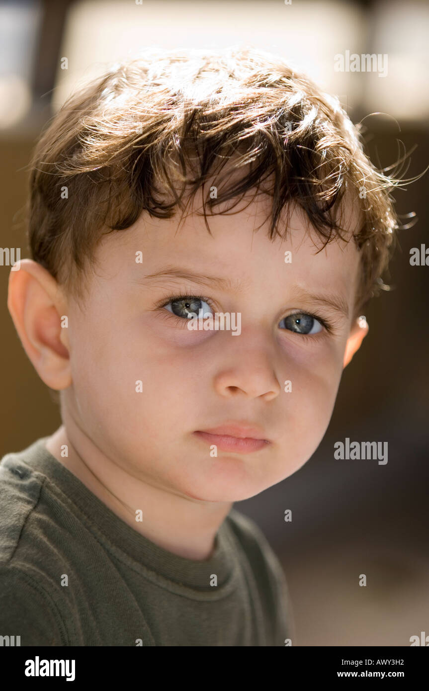 Head and shoulders portrait of a 2 years old boy looking at the camera Stock Photo