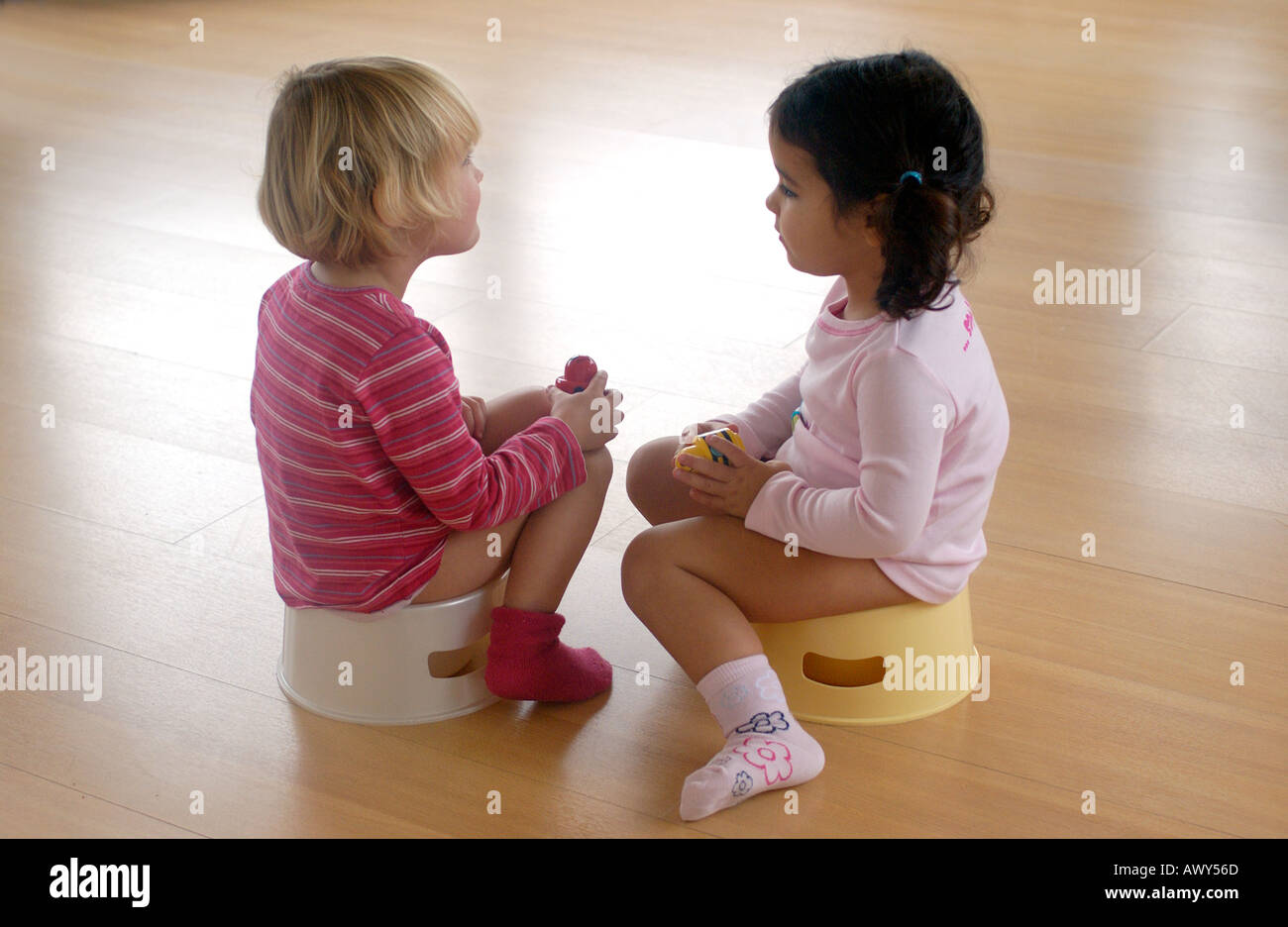 Two toddler girls using a potty Stock Photo - Alamy
