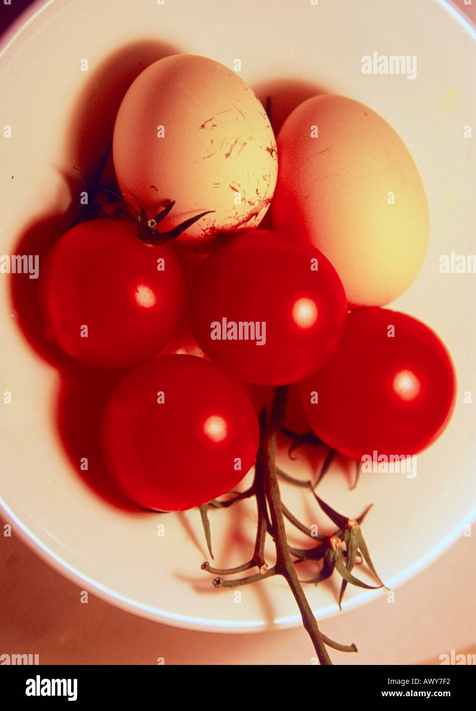 Two and eggs and some tomatoes in a white bowl Stock Photo