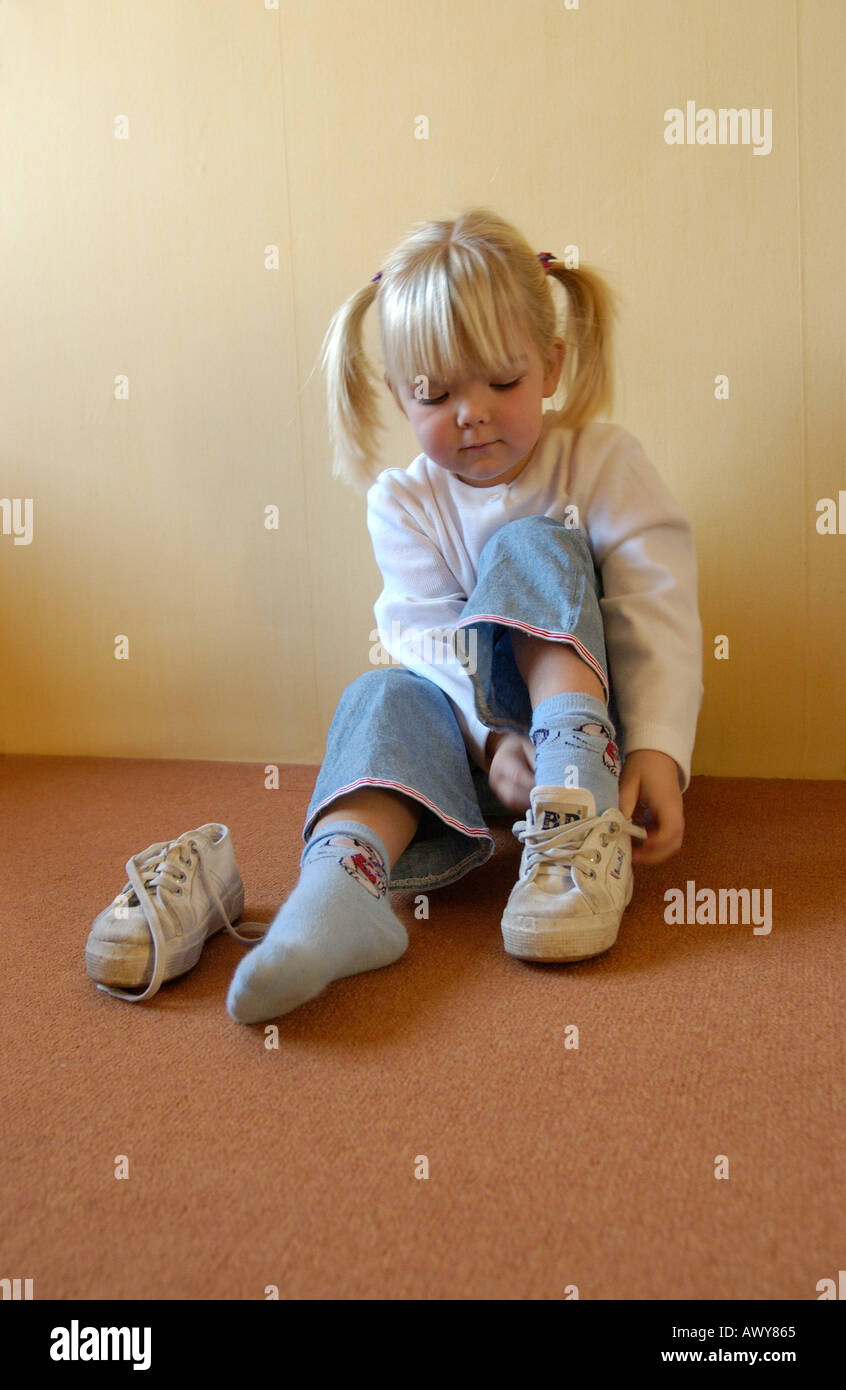 Little girl putting on her shoes Stock Photo - Alamy