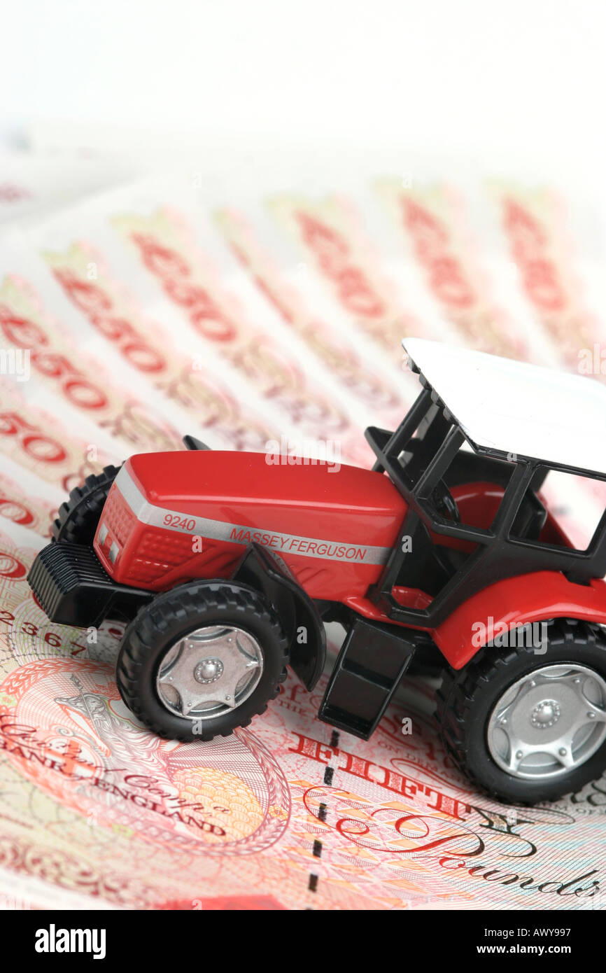 Tractor on a pile of fifty pound notes money Stock Photo