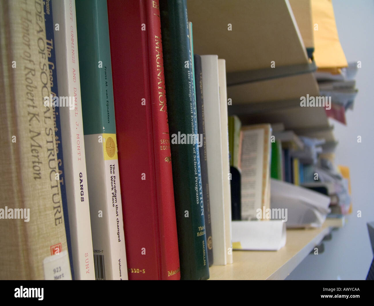 Books sit on a shelf in an office Stock Photo Alamy