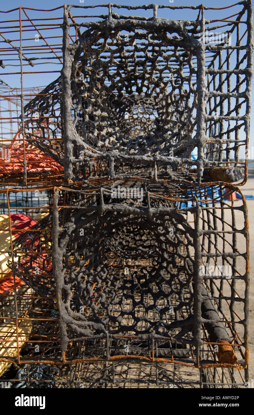 Lobster traps are stacked on a wharf, ready for use in the commercial lobster fishing industry. Stock Photo