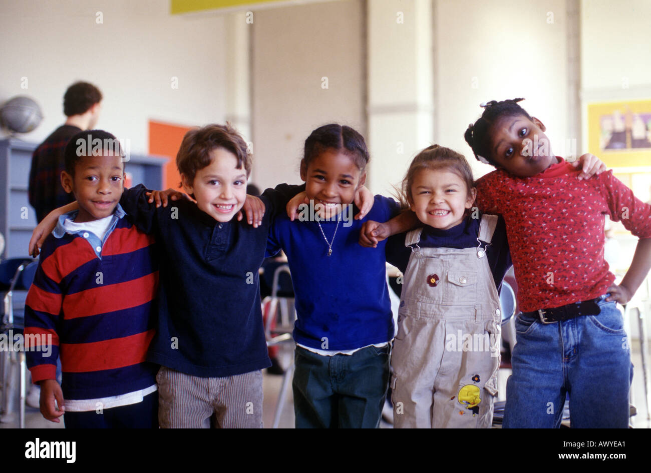 Five multi cultural first graders in classroom smile for the camera Stock Photo