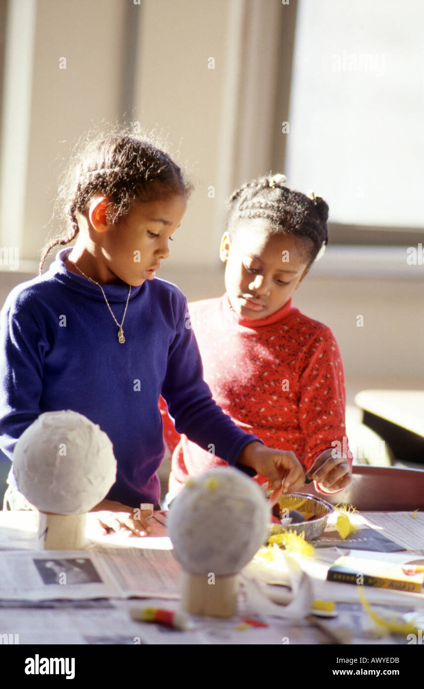 Two first grade girls work on an art project in classroom Stock Photo