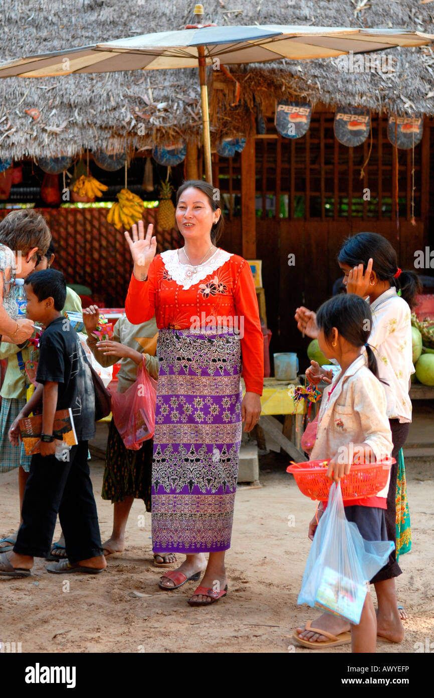 Cambodia , Angkor , Preah Khan Temple , street scene of pretty smiling local female vendor in national dress with her children Stock Photo