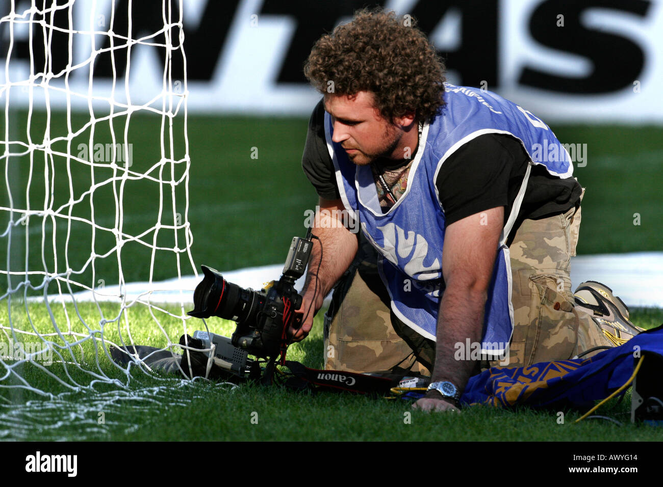 A sports photographer sets up a remote control camera at a soccer match