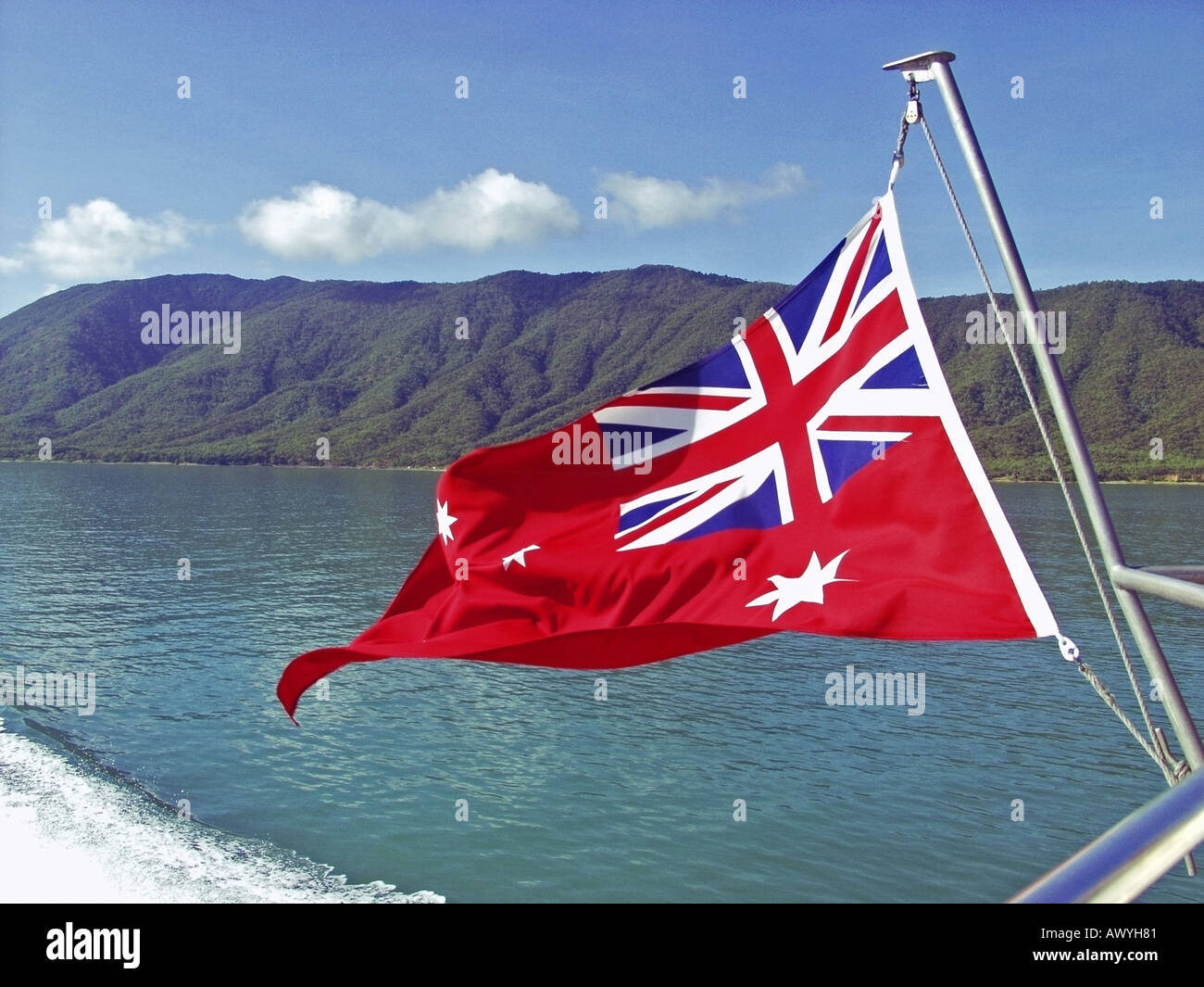 Australia Tropical Queensland flag on stern of catamaran boat on ocean with coastal behind JMH0811 Photo - Alamy