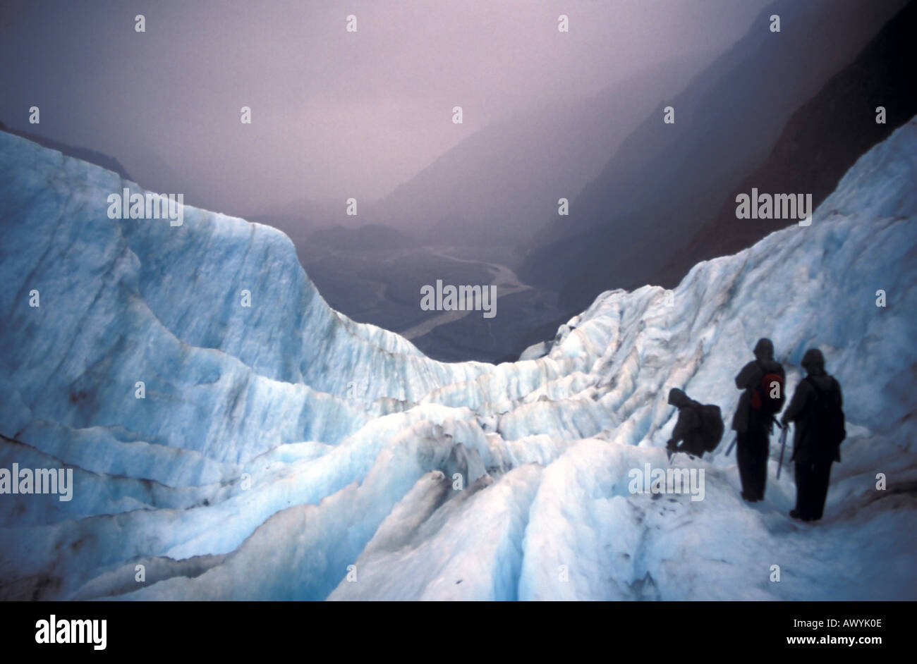 Ecotourists descending Franz Joseph Glacier in bad weather Westlands National Park South Island New Zealand Stock Photo