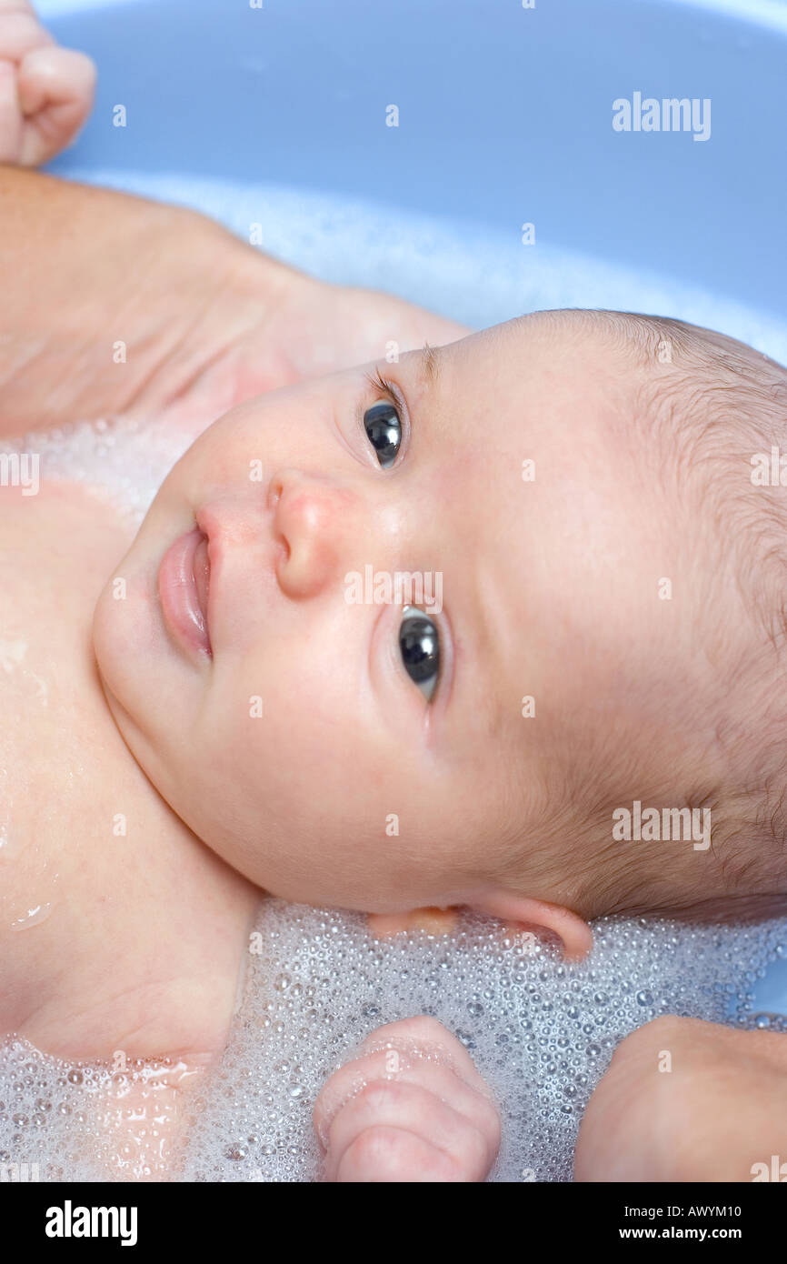 Baby girl having her first bath at home and smiling Stock Photo Alamy