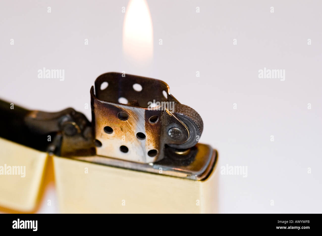Lit zippo lighter showing brass casing and flame Stock Photo