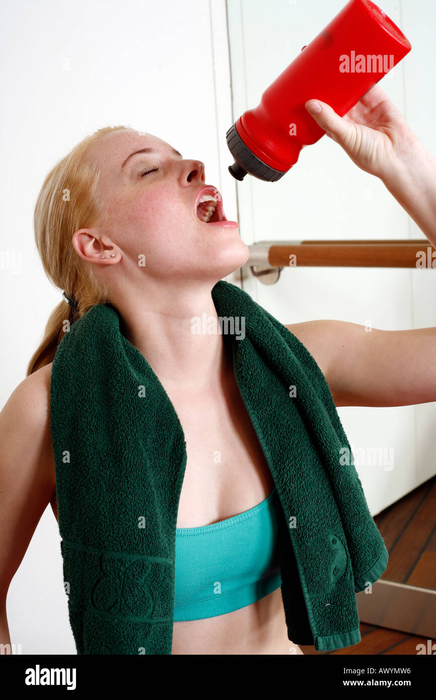 Young woman drinking water during an exercise session Stock Photo