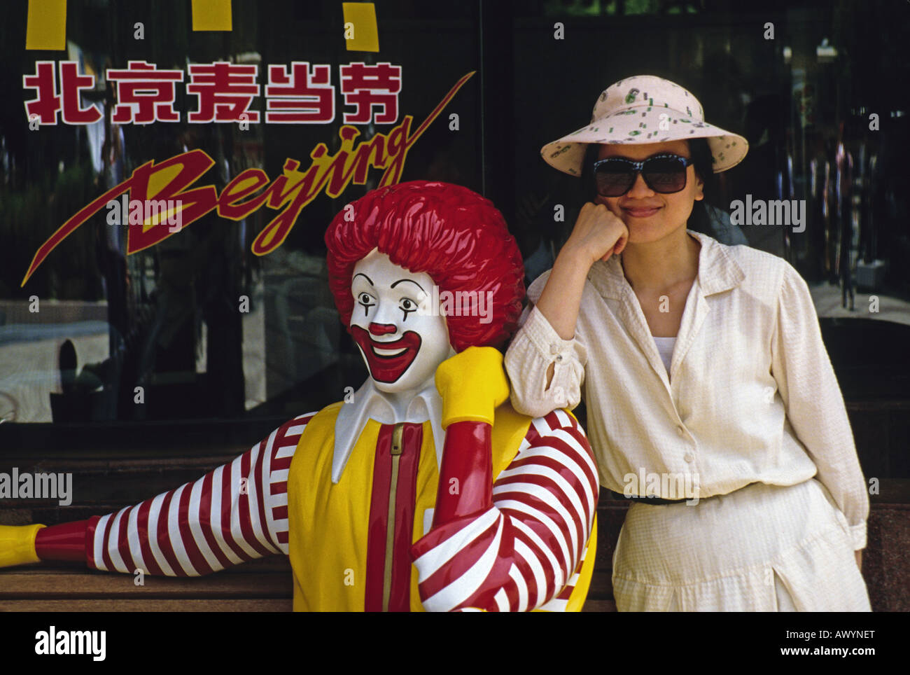 Pretty Chinese woman with statue of Ronald McDonald at fast food outlet in Beijing Stock Photo